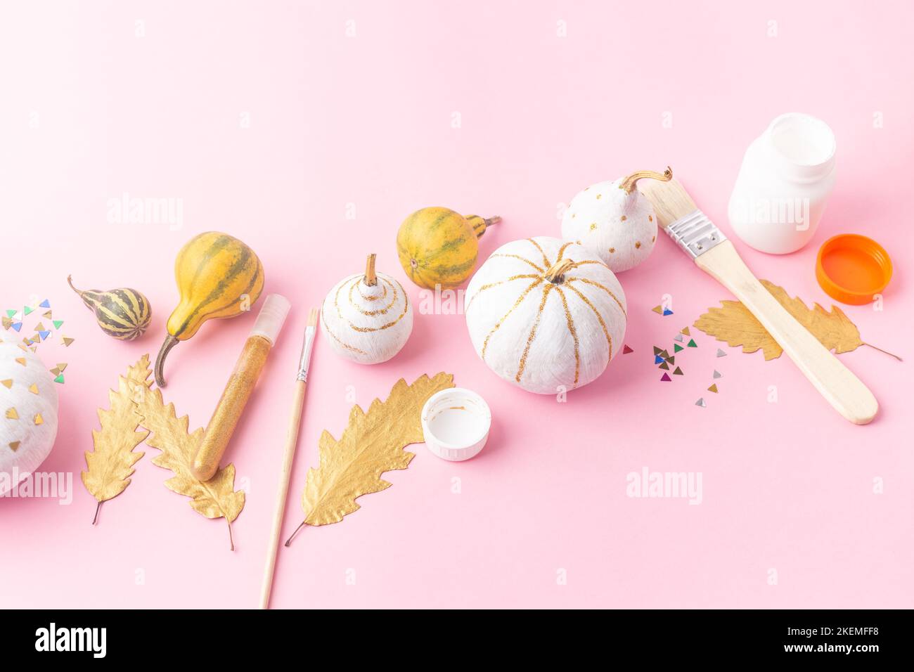 Autumn concept craft for kids, felt pumpkins with eyes and decorated pumpkins white and gold leaves Stock Photo