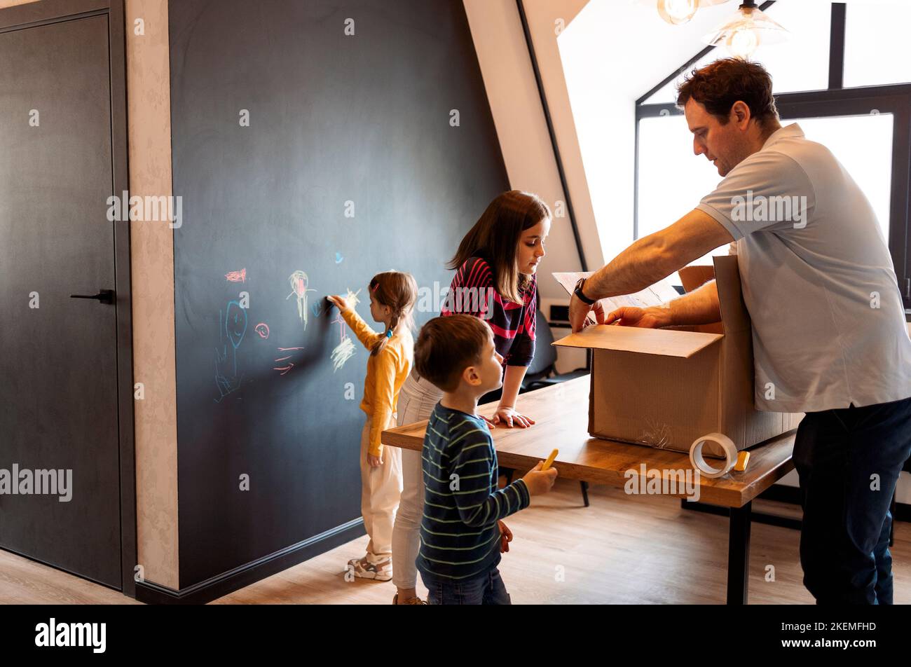 Happy family playing into new home. Child having fun together with