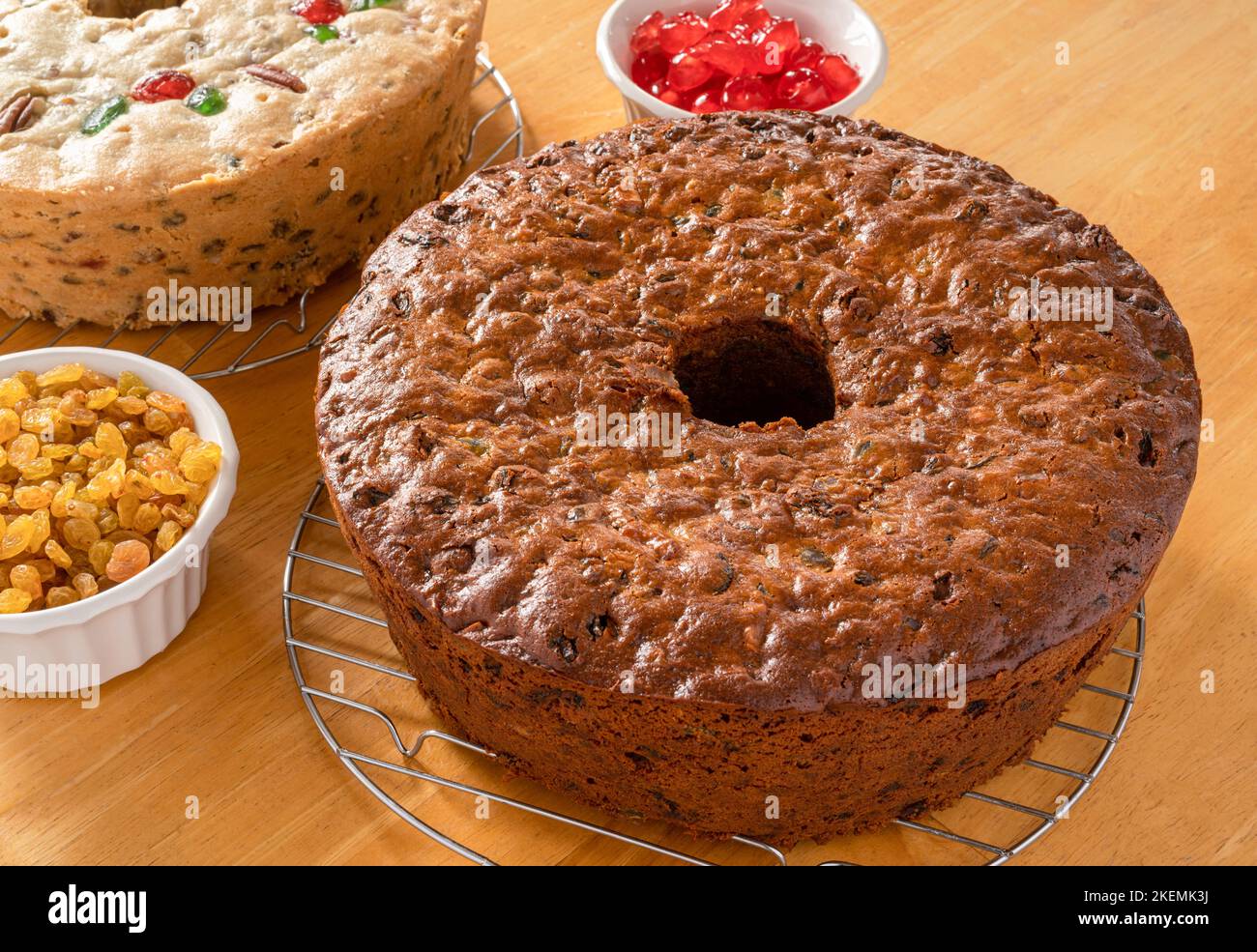Homemade dark and light fruitcakes fresh out of the oven and cooling on baking racks. Stock Photo