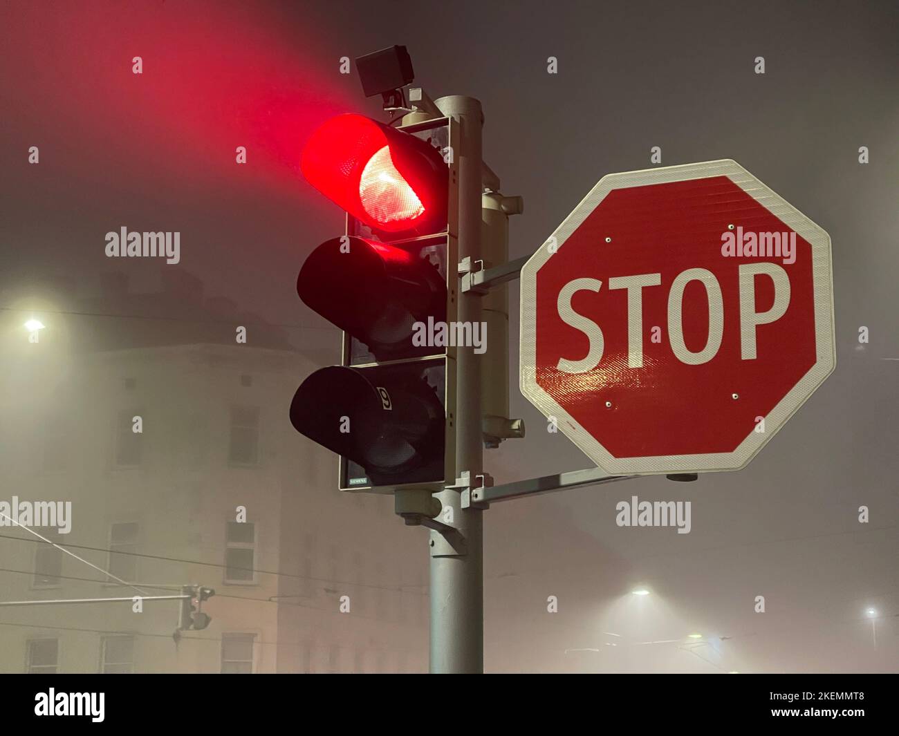 Red traffic lights glowing in the fog near big stop sign Stock Photo ...