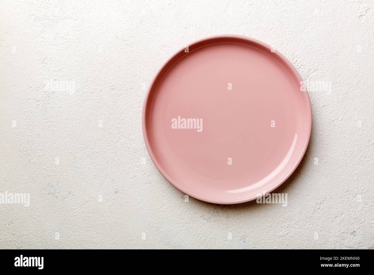 Top view of empty pink plate on cement background. Empty space for your ...