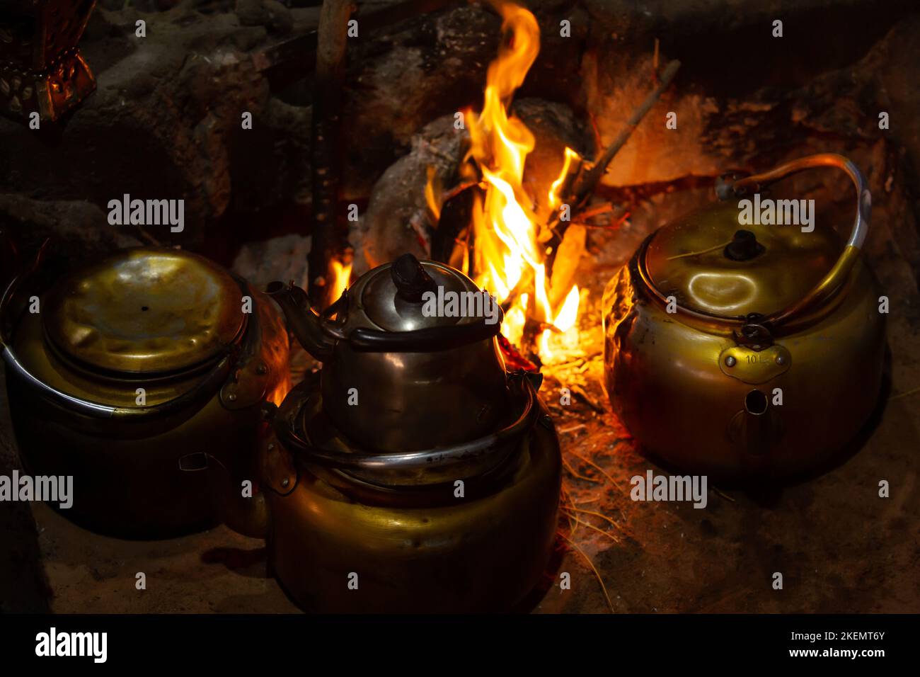 Few teapots with Bedouin tea, kettle on campfire at night, Jordan, Wadi