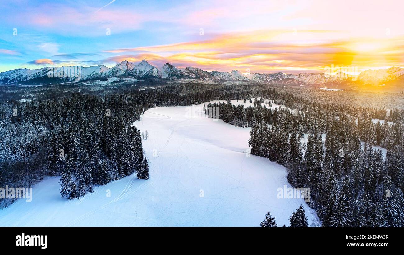 Snow capped mountains in the winter, aerial view. Aerial panorama of winter mountain landscape and colorful sunset sky. Tatra high mountains and magic Stock Photo