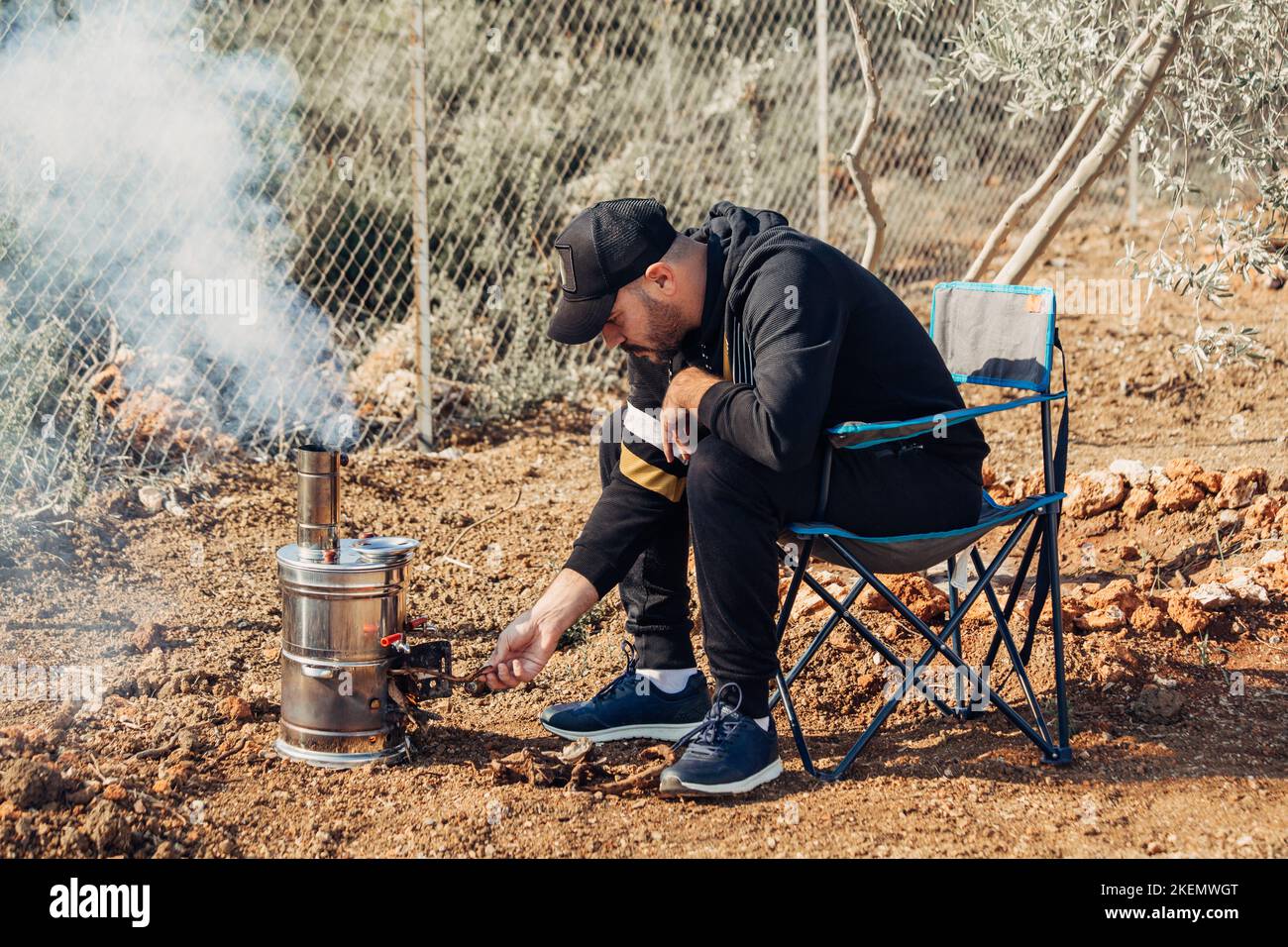 Man lighting samovar for tea, coffee, hot water in camp. Stock Photo