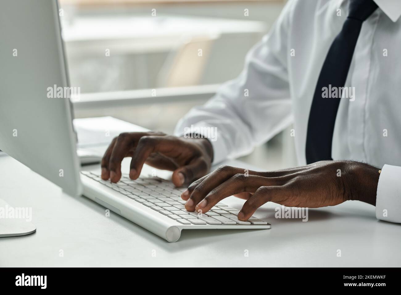 Close-up of African American businessman typing on keyboard while working on computer at office Stock Photo