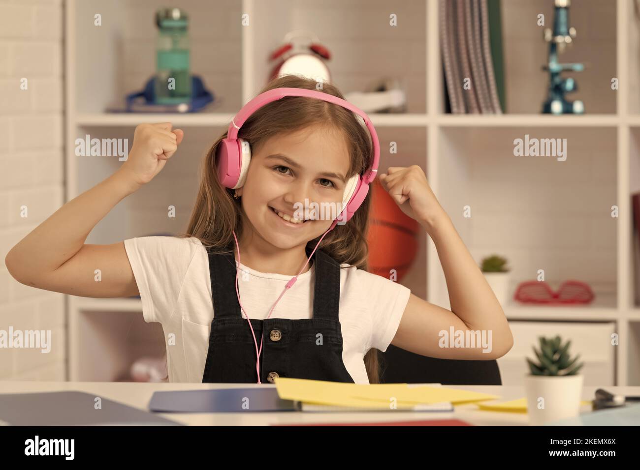 happy kid listen to music in headphones at school classroom. happiness