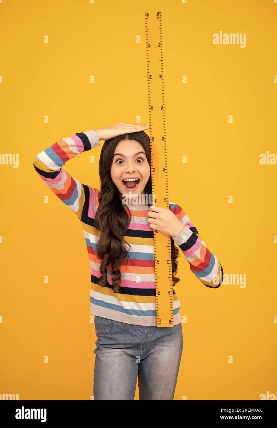 Kid height measure, growth measurement. Schoolgirl in school uniform