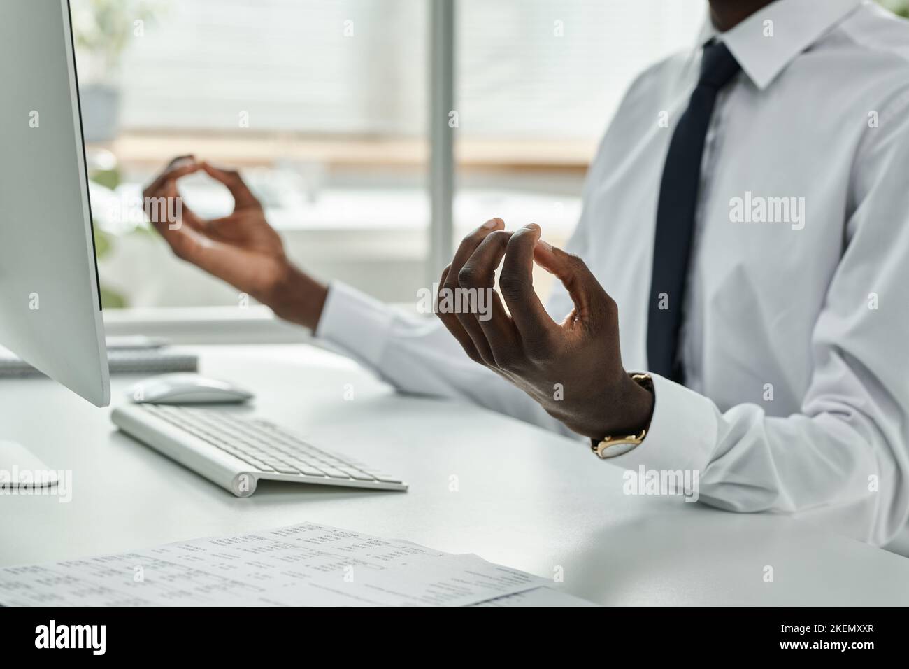Close-up of African American businessman meditating and relaxing at his workplace during working day Stock Photo
