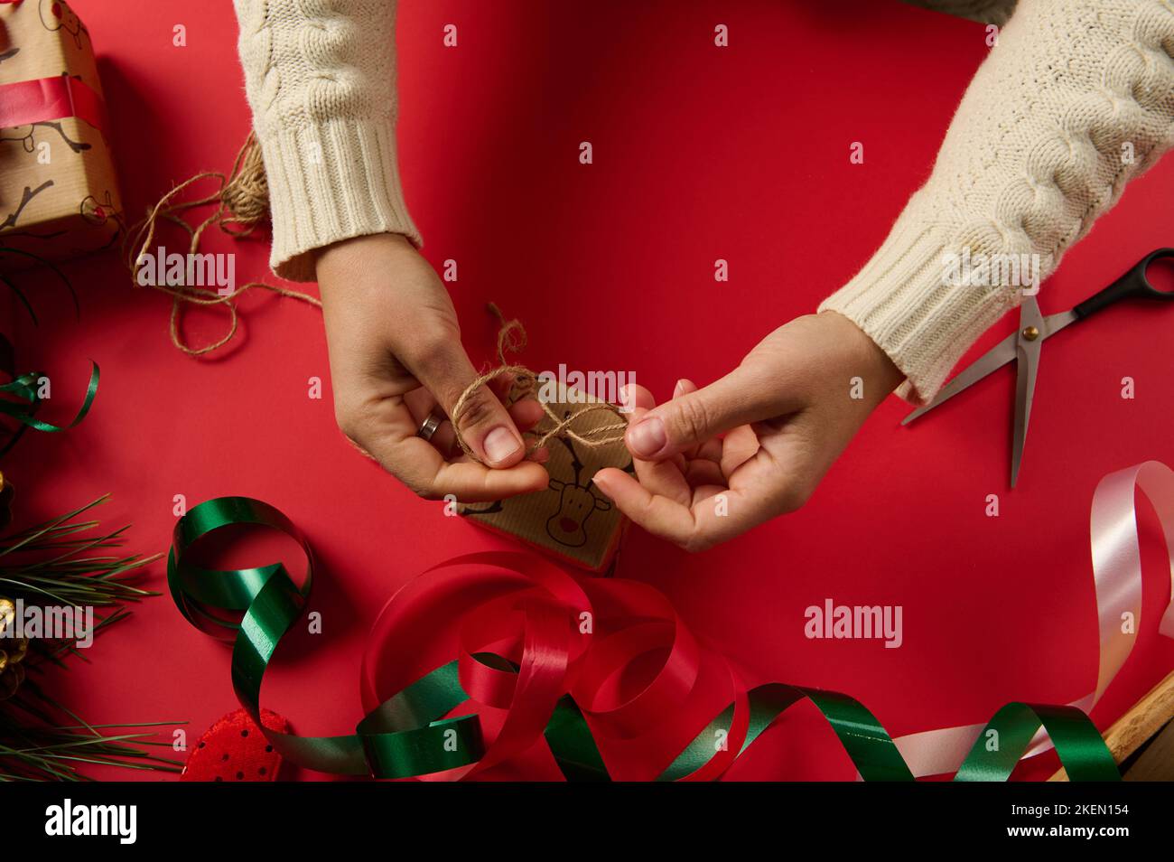 Top view craftswoman wrapping Christmas present in a decorative gift ...