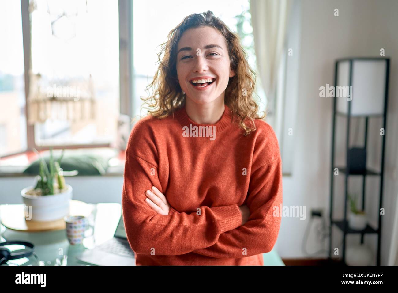 Young smiling pretty lady standing at home looking at camera. Stock Photo
