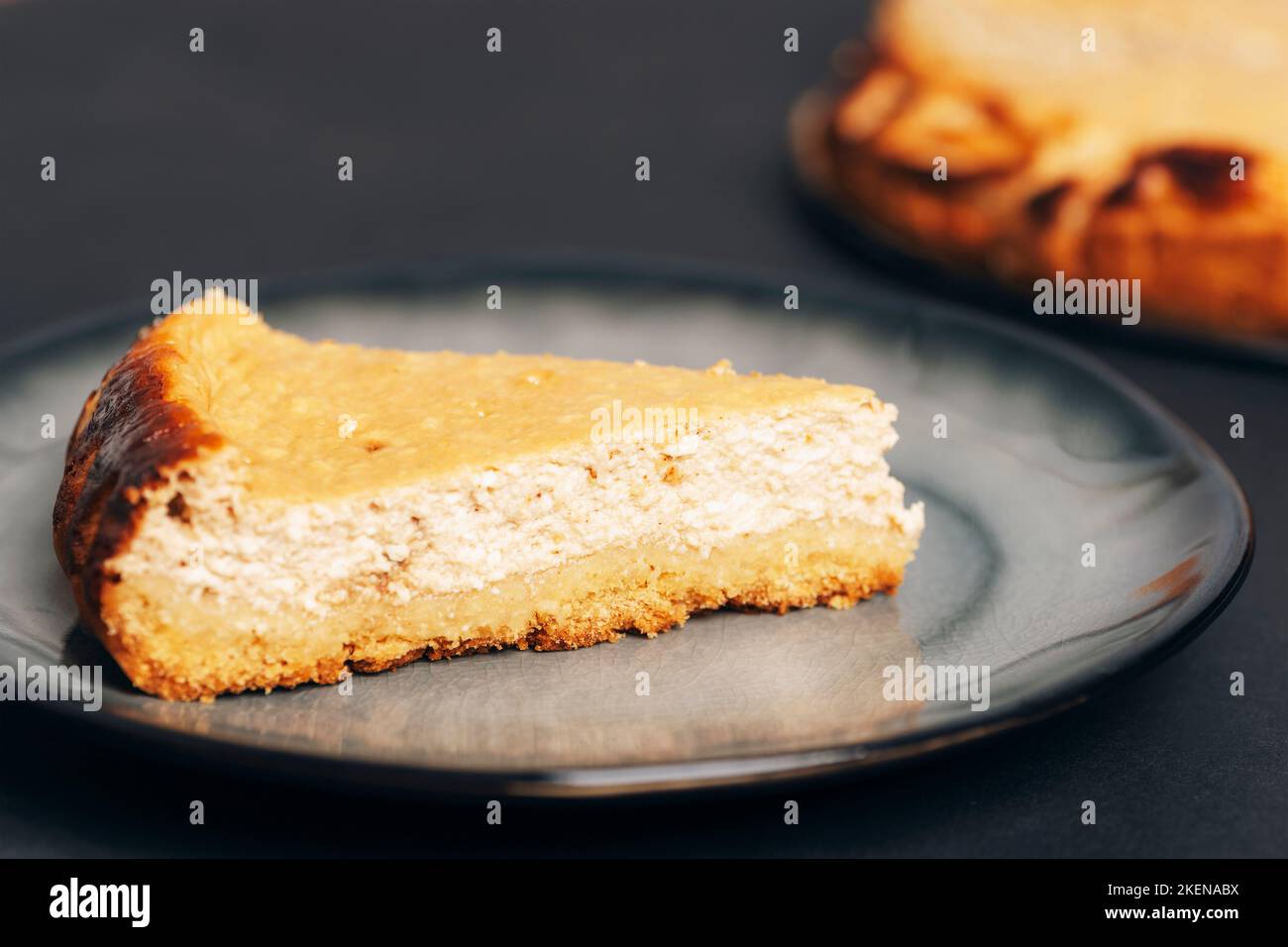 Homemade cheesecake on a gray plate on black table, closeup. Stock Photo