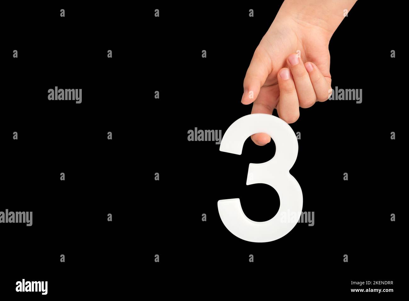 number three in hand isolated on black background. Number three in a