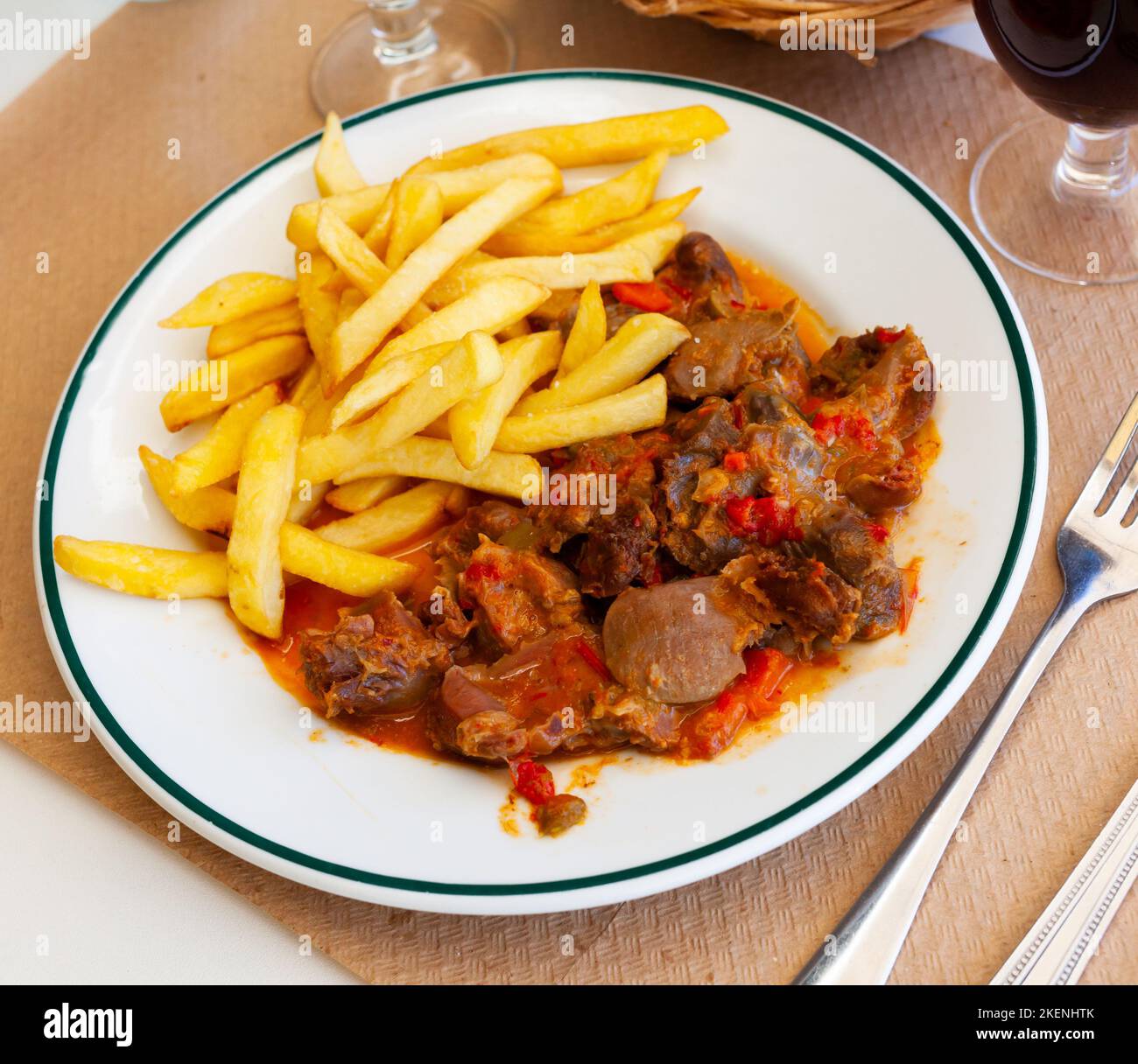 Stewed chicken gizzards in gravy with french fries Stock Photo Alamy