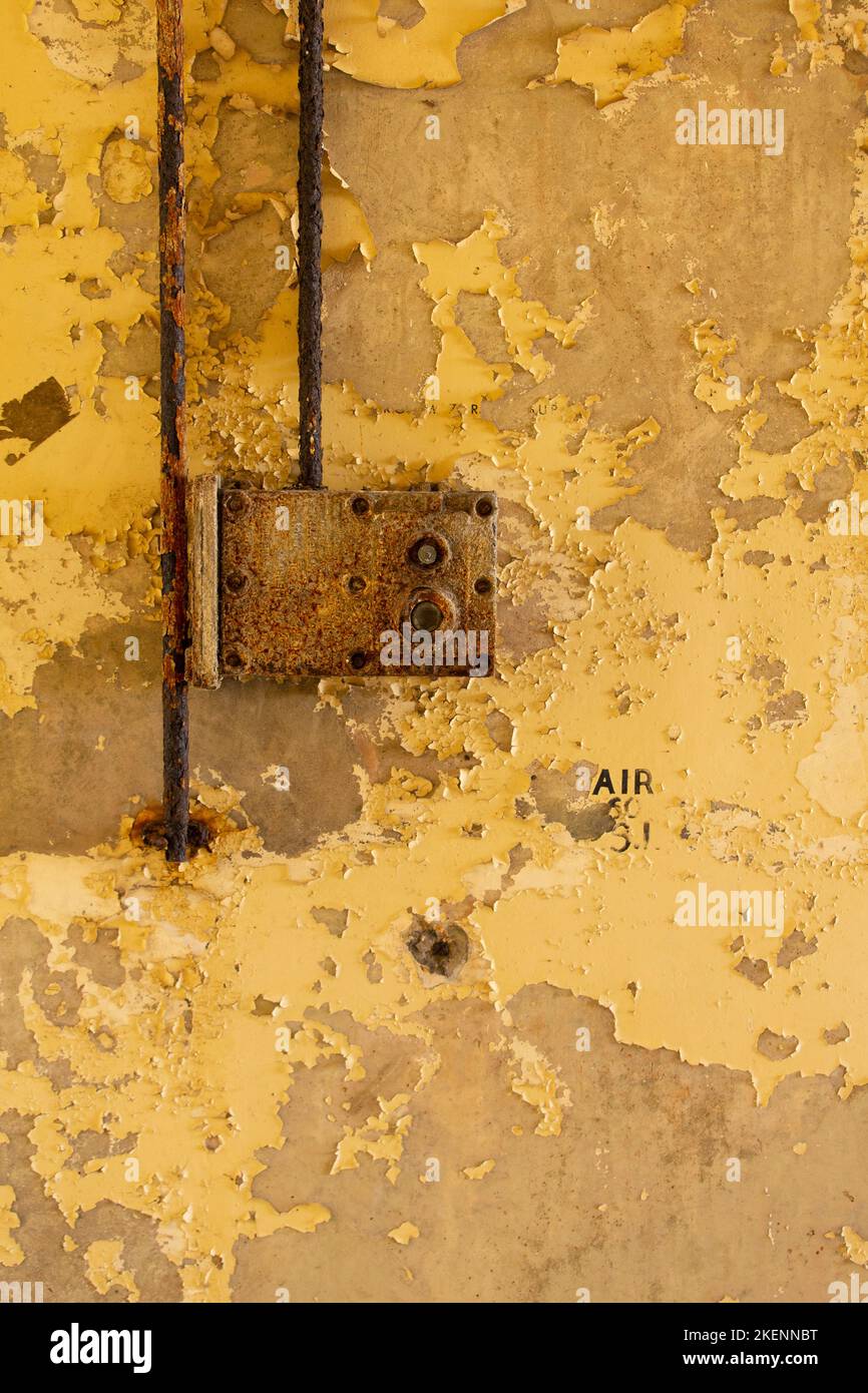 Rusty electrical switch on a wall of distressed yellow paint Stock Photo