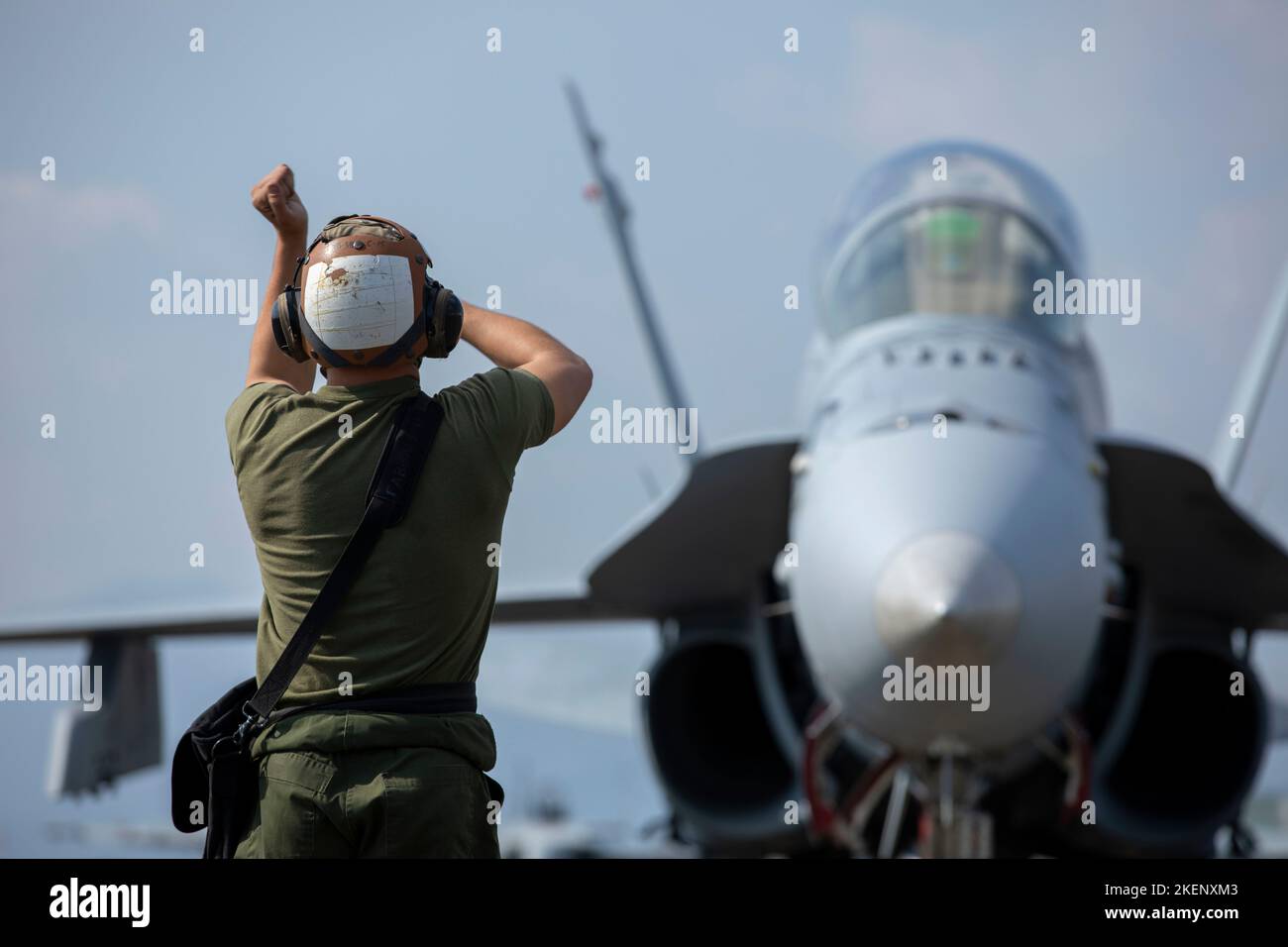 U.S. Marine Corps Lance Cpl. Richard Blake, a fixed-wing aircraft with Marine Fighter Attack Squadron (VMFA) 312, signals to an F/A-18D Hornet aircraft during pre-flight checks at Japan Air Self-Defense Force Nyutabaru Air Base, Japan, Nov. 9, 2022. Under the Unit Deployment Program with Marine Aircraft Group 12, VMFA-312  participates in the Aviation Training Relocation Program to improve operational readiness and interoperability with Japan Air Self-Defense Forces in the Indo-Pacific theater. (U.S. Marine Corps photo by Sgt. Jackson Ricker) Stock Photo