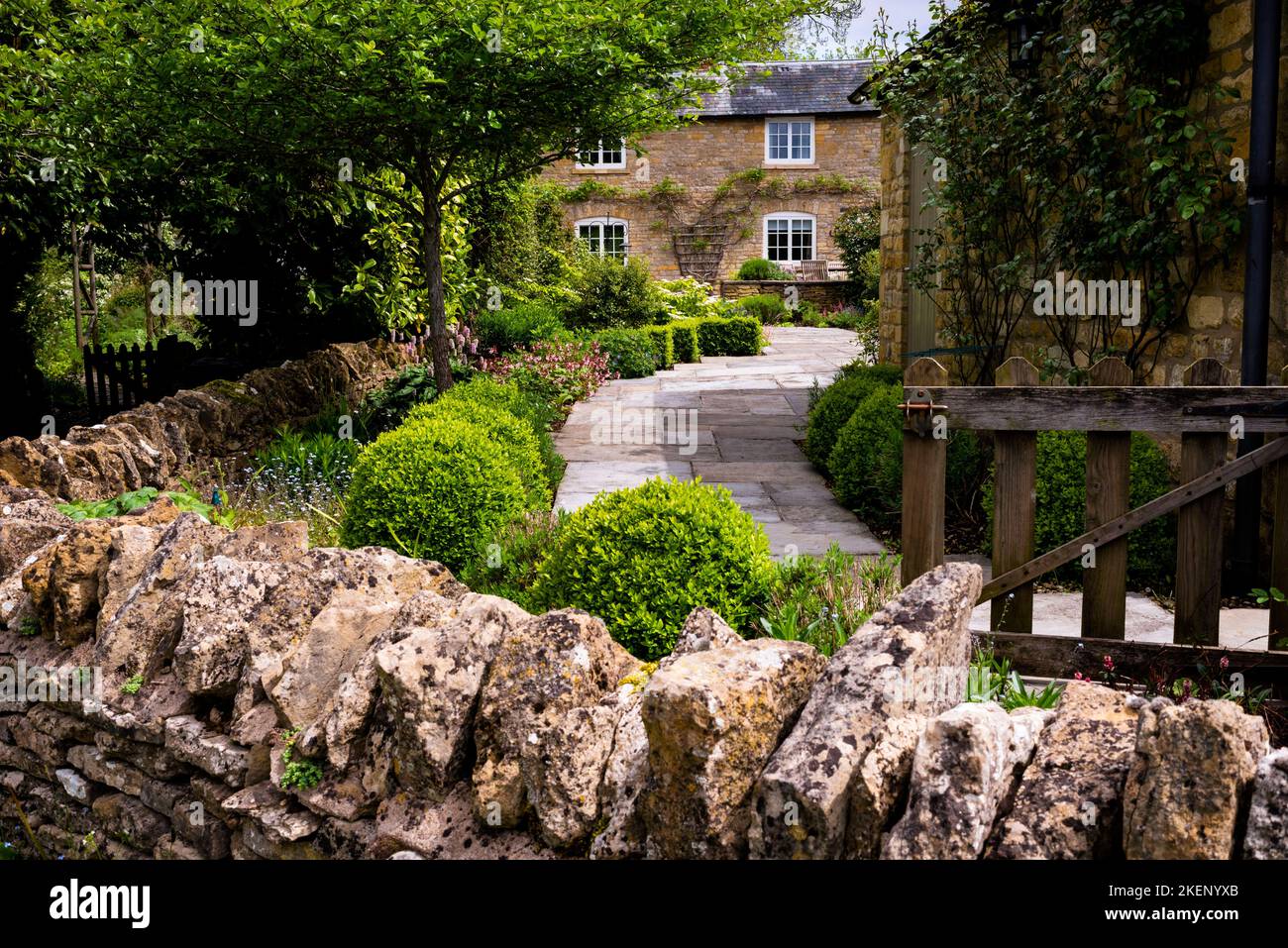 Dry stacked stone wall leading the way to a honey colored estate in the