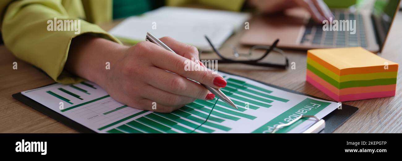Analyst employee working with financial report on computer and documents Stock Photo