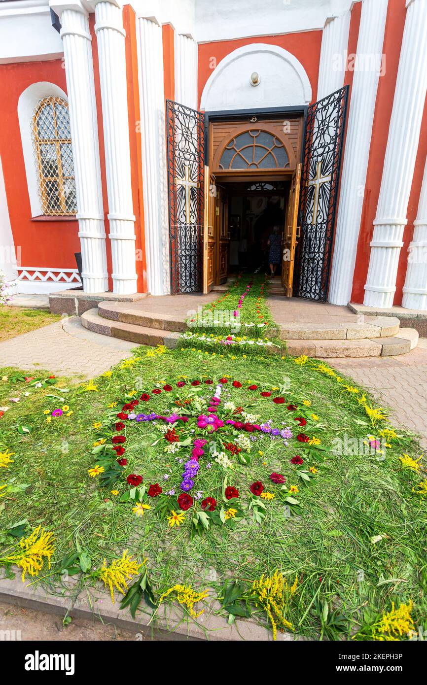 Entrance to an Orthodox church strewn with flowers and grass. Cathedral of the Resurrection of Christ in Staraya Russa, Russia Stock Photo