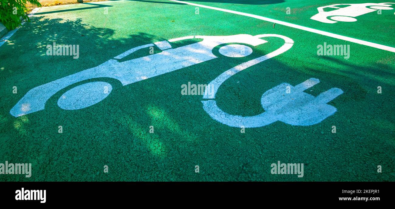 Signs for electric vehicle charging, on the ground at a charging
