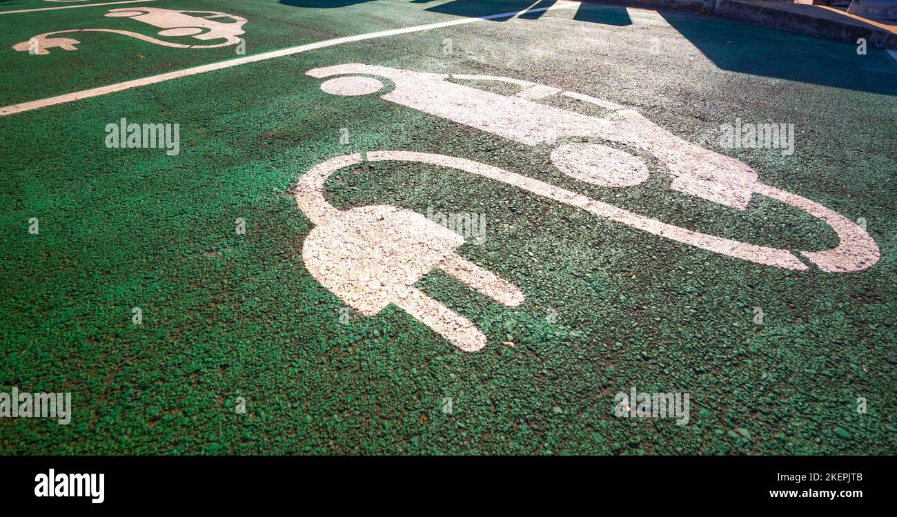 Signs for electric vehicle charging, on the ground at a charging