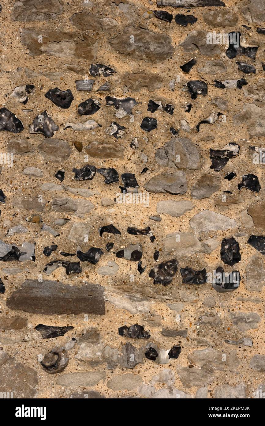 Newly repaired wall made with stones and flint as background texture ...