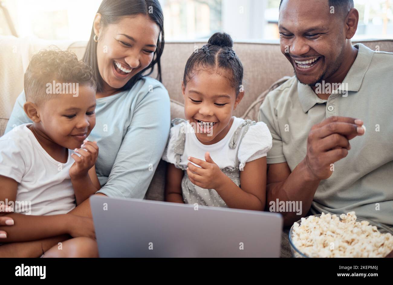 Black family, laptop and sofa for movie, popcorn and streaming on internet in home living room together. Happy family, computer and comedy movies on Stock Photo