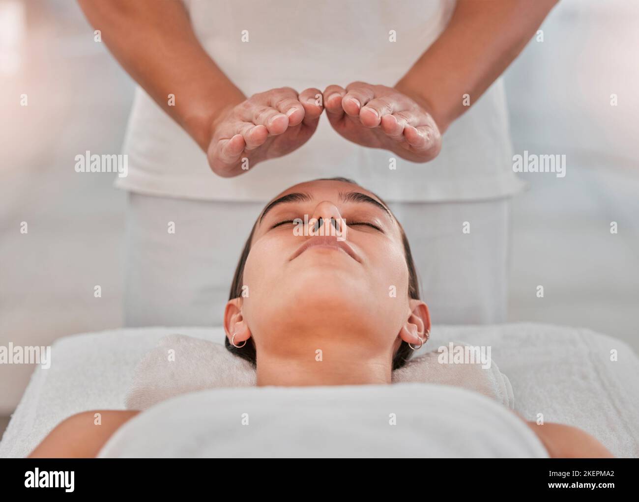 Relax, health and reiki with woman on spa table for healing energy, zen and alternative medicine. Peace, wellness and luxury with hands of massage Stock Photo