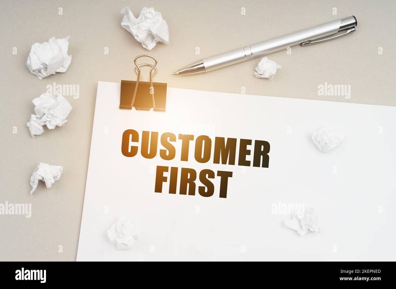 First Customer Note Economy and business concept. On a gray surface, a pen, crumpled paper ...