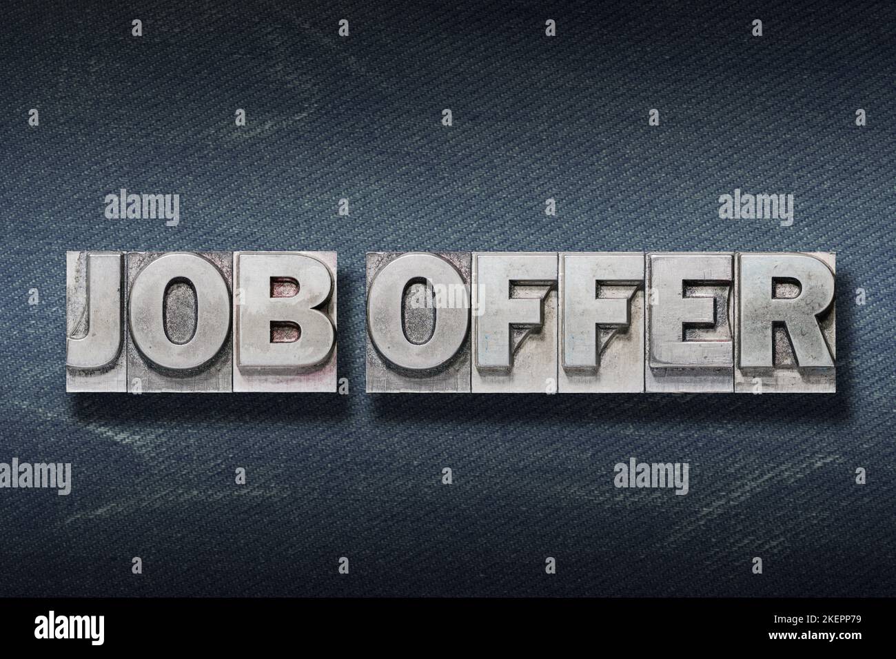 job offer phrase made from metallic letterpress on dark jeans background Stock Photo