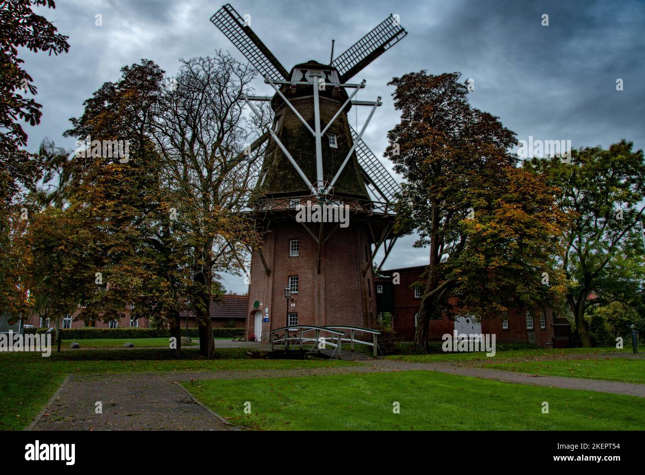 Three-storey gallery Dutchman, in a well-kept, romantic atmosphere. In front of the windmill is a small park-like area with a small white-painted wood Stock Photo