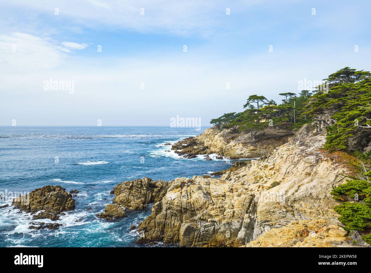 Monterey Bay, California. Rocky coastline, cypress trees, Pacific Ocean, and beautiful cloudy sky background Stock Photo