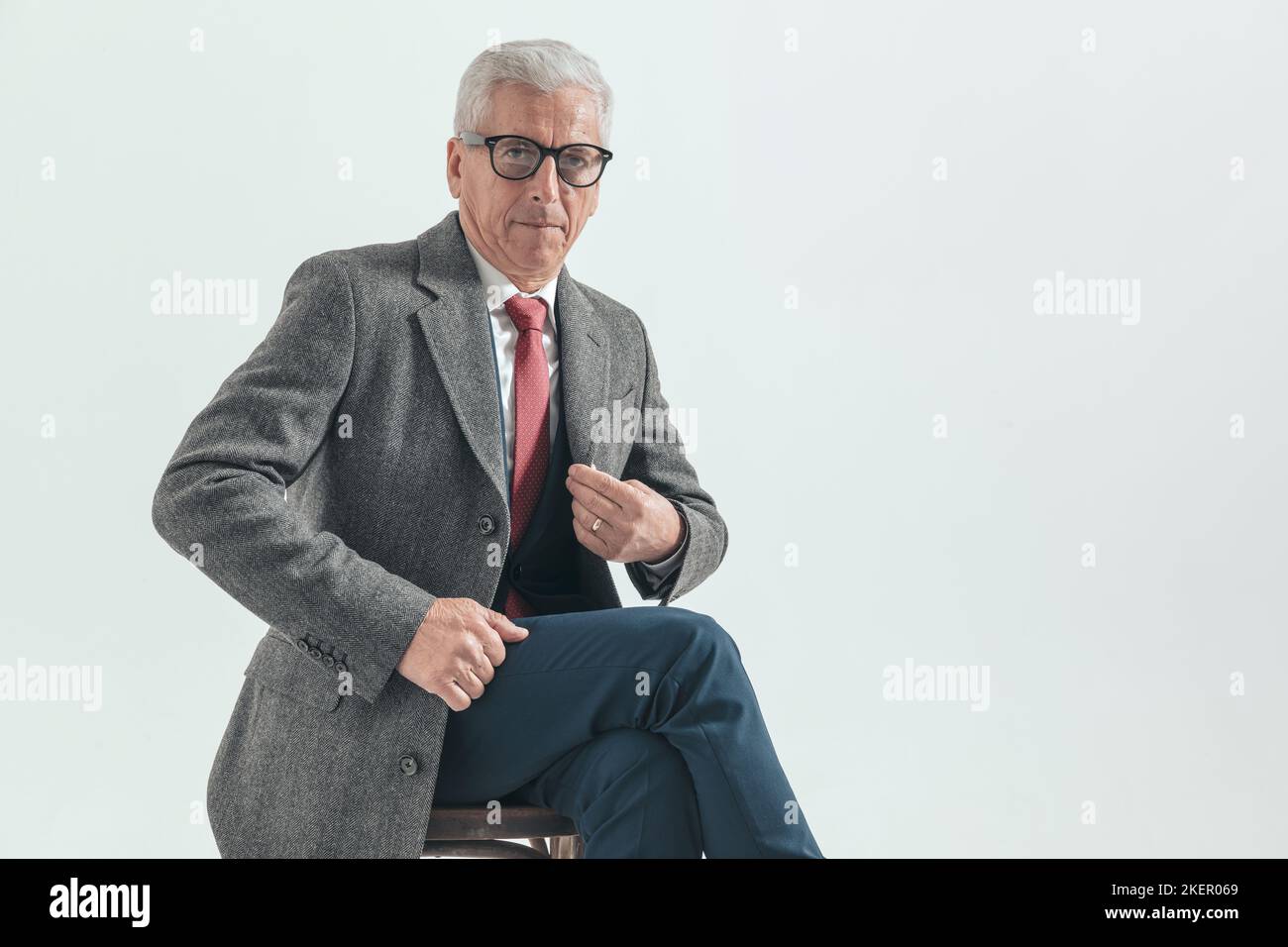 Elegant Old Man In His 60s With Grey Hair Adjusting Longcoat While