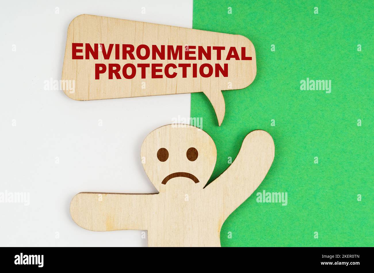 Environmental concept. On a green and white background, a sad wooden ...