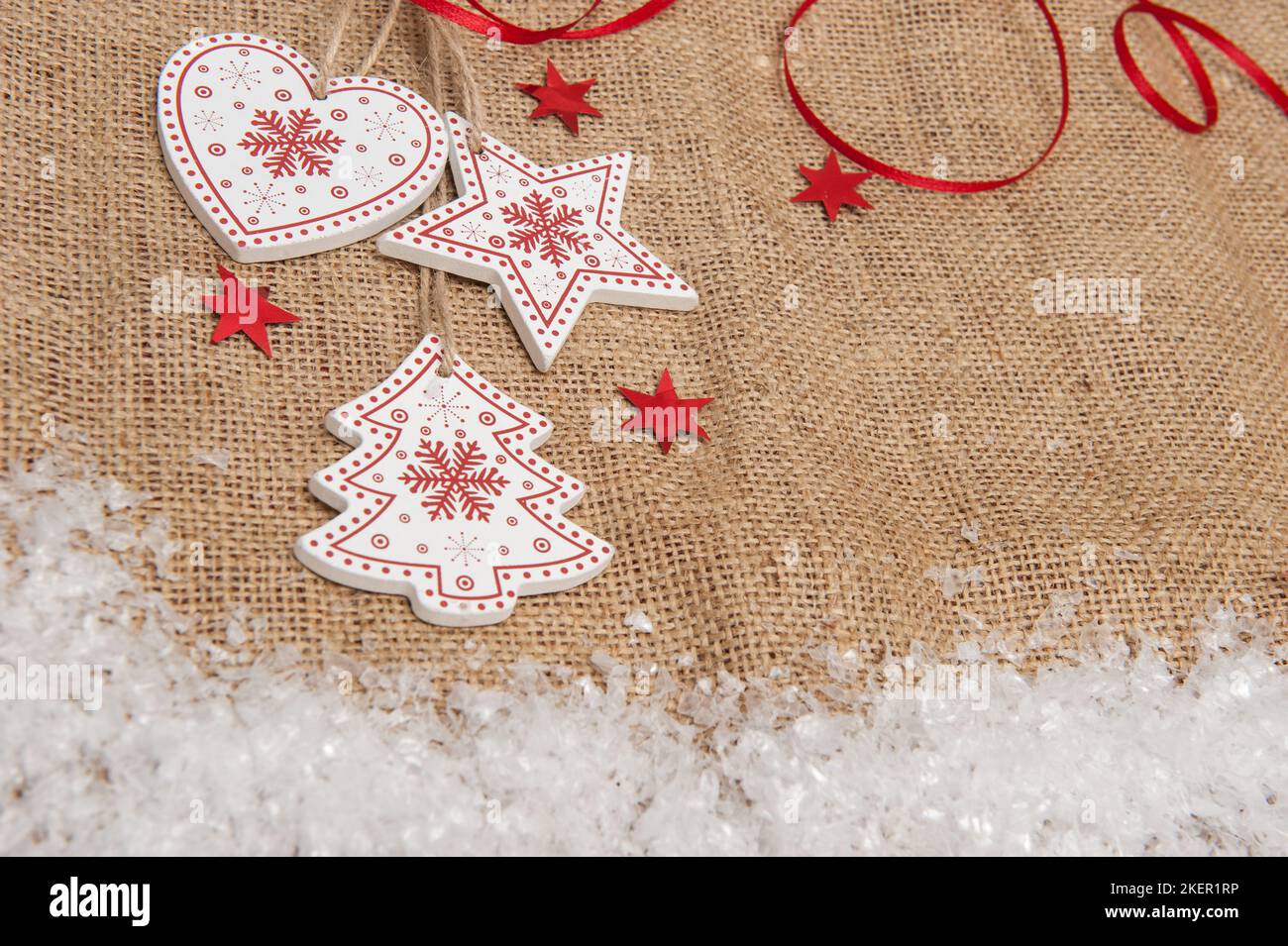 Wooden Christmas decorations on a background of burlap with artificial snow Stock Photo