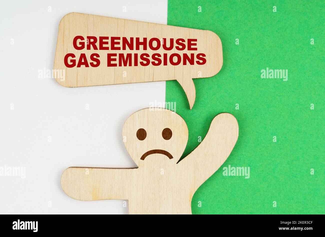 Environmental concept. On a green and white background, a sad wooden ...