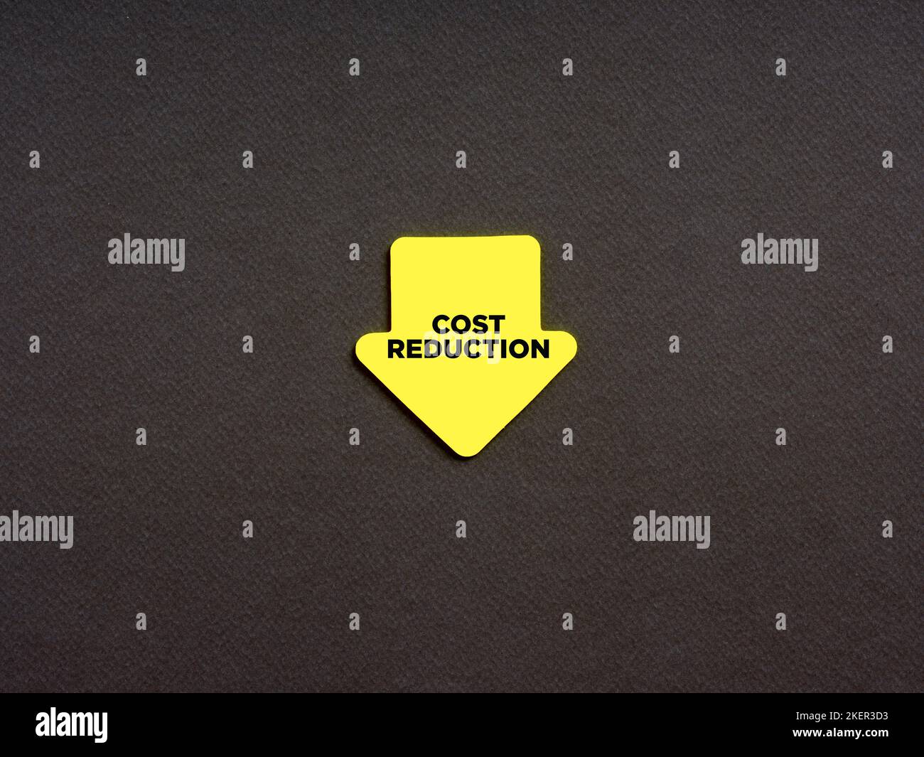 Cost reduction in business and finance concept. The word cost reduction on an arrow shaped note paper. Stock Photo