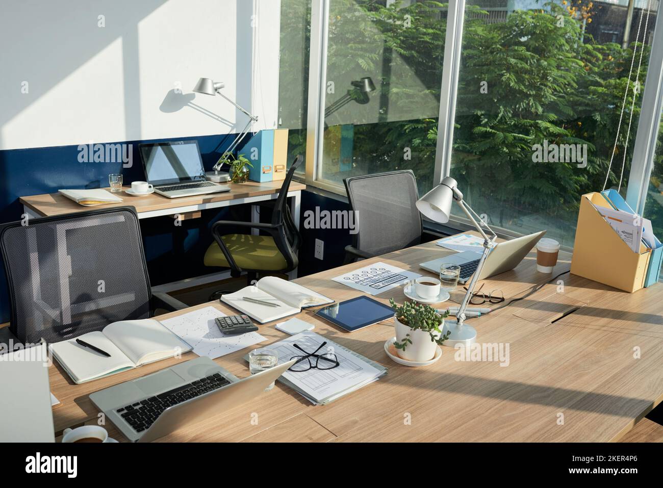 Tables with documents and computers in coworking space Stock Photo