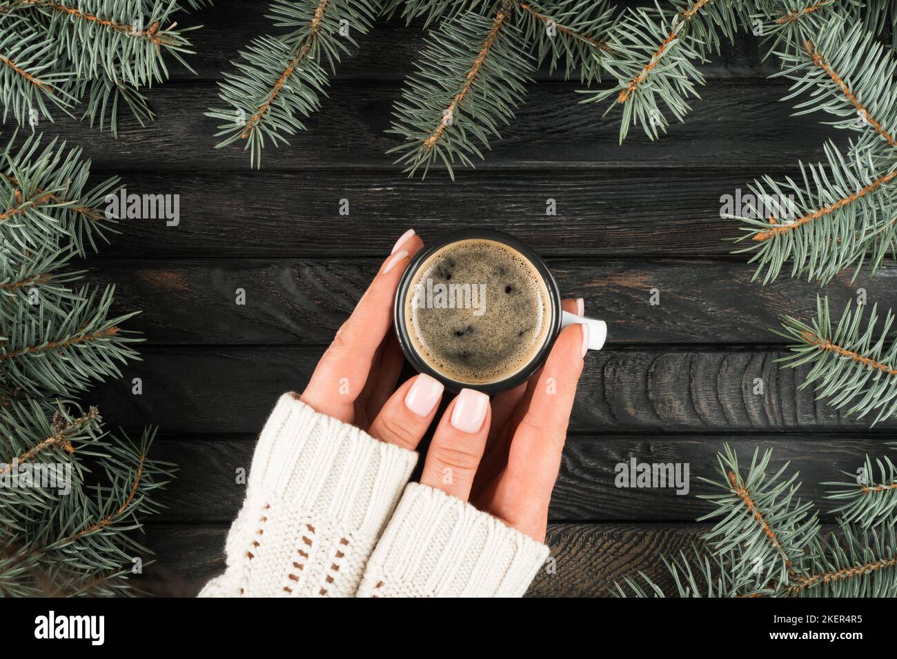 Female hands in white sweater hold cup of hot aromatic black coffee ...