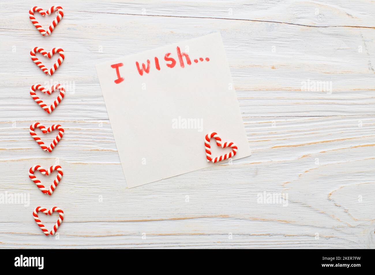 notebook with wish list on vintage wooden table with candy canes. christmas planning concept Stock Photo
