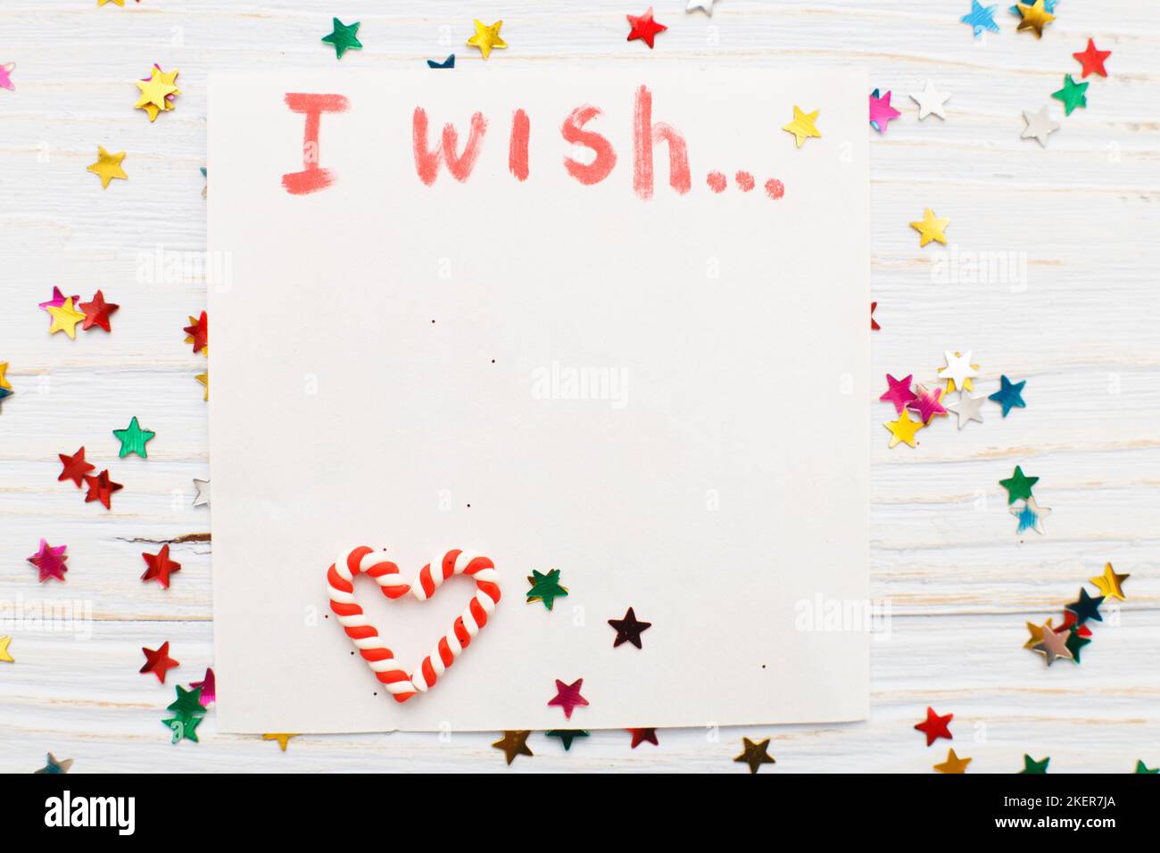 notebook with wish list on vintage wooden table with candy canes. christmas planning concept Stock Photo