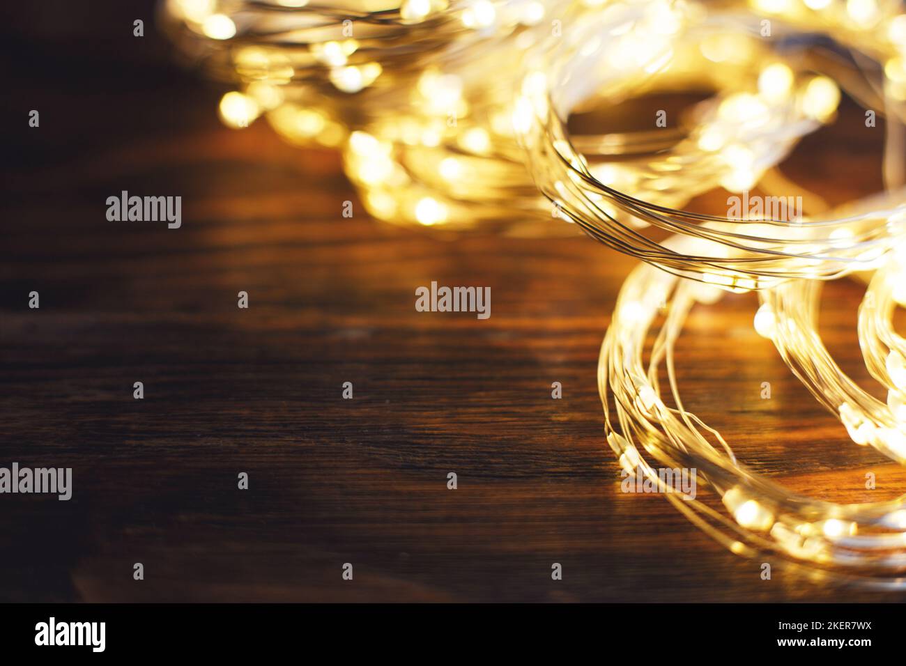 christmas beautifull shiny gold garland on a wooden brown background. sparkle festive blurred background with copy space for your text Stock Photo