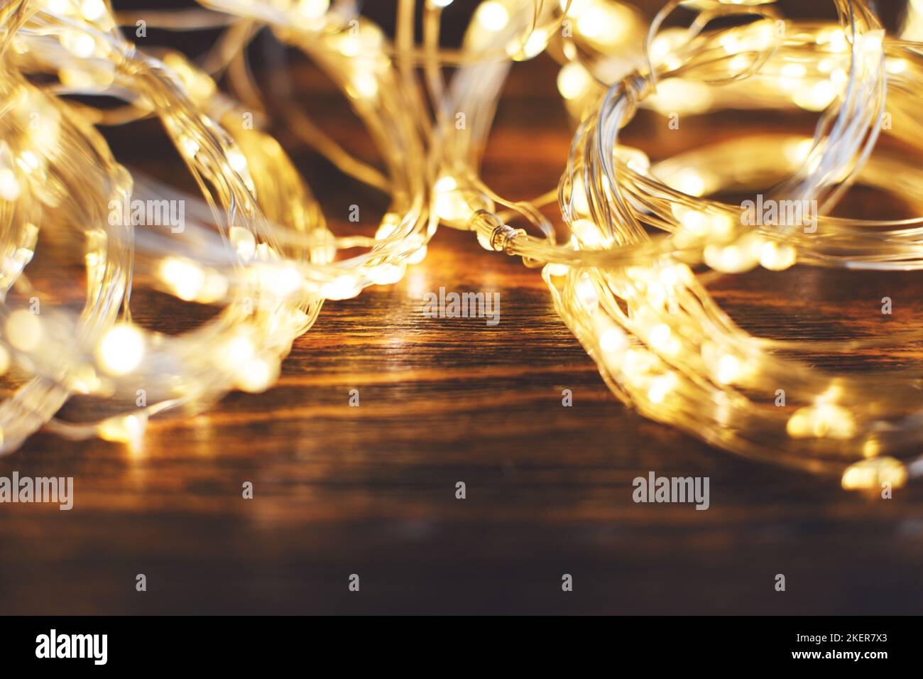 christmas beautifull shiny gold garland on a wooden brown background. sparkle festive blurred background with copy space for your text Stock Photo
