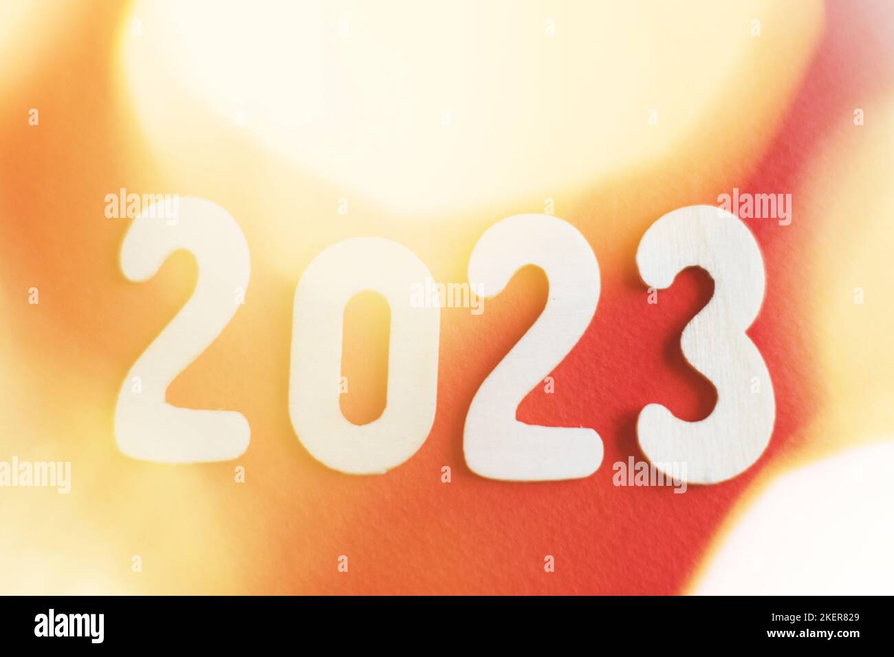wooden number 2023 on christmas beautifull shiny gold and red background. sparkle festive blurred bokeh. Stock Photo