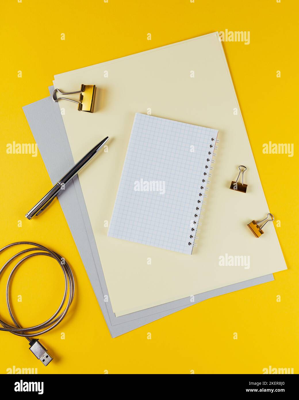 Yellow office desk table with blank notebook and other office supplies