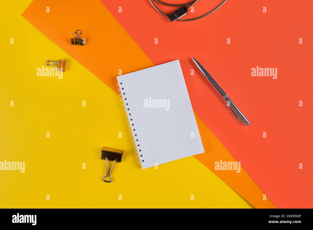 Yellow office desk table with blank notebook and other office supplies