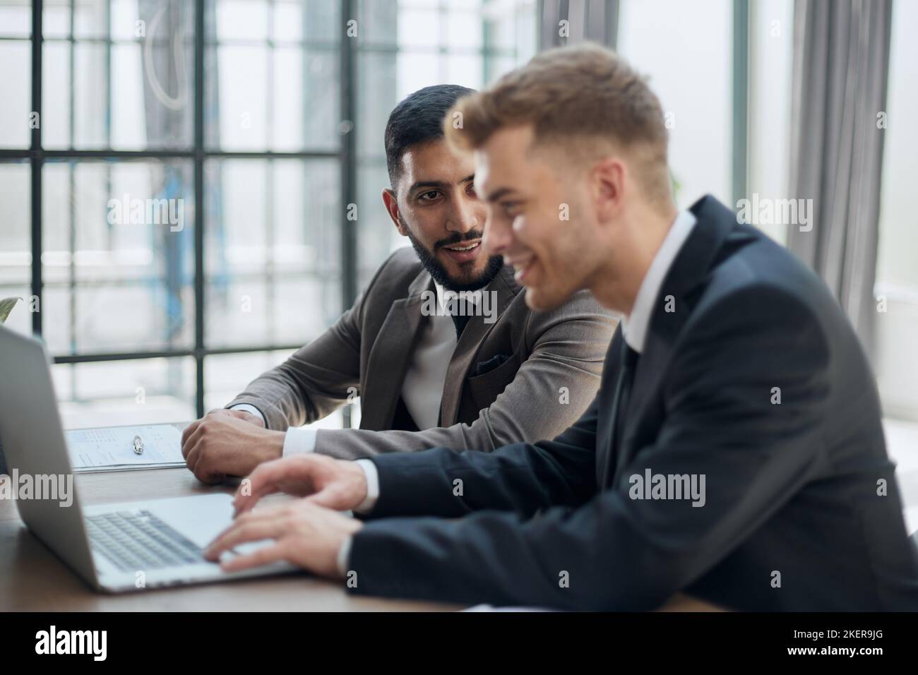 two professional businessmen discussing and using desktop computer in office Stock Photo