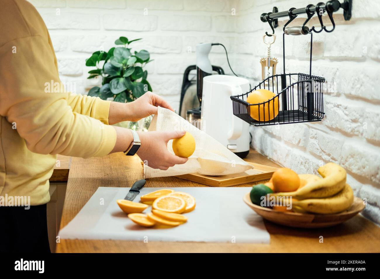 How to Dry Orange Slices for Holiday Decor. Process of Drying Orange Slices in the Oven. Woman cutting slices of orange and citrus fruits for drying Stock Photo