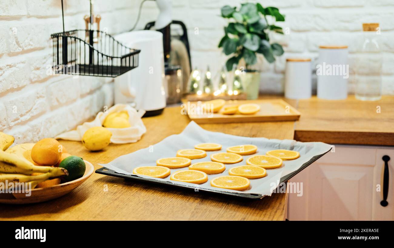 How to Dry Orange Slices for Eco friendly zero waste Holiday Decor. Close up Process of Drying Orange Slices in the Oven. Stock Photo