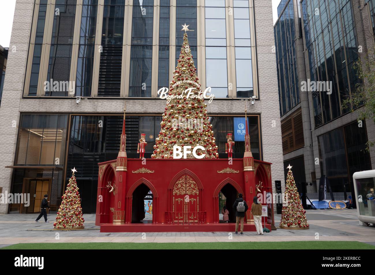 SHANGHAI, CHINA - NOVEMBER 14, 2022 - Golden Christmas trees and red decorations are seen inside and outside the BFC Bund Financial Center mall on the Stock Photo