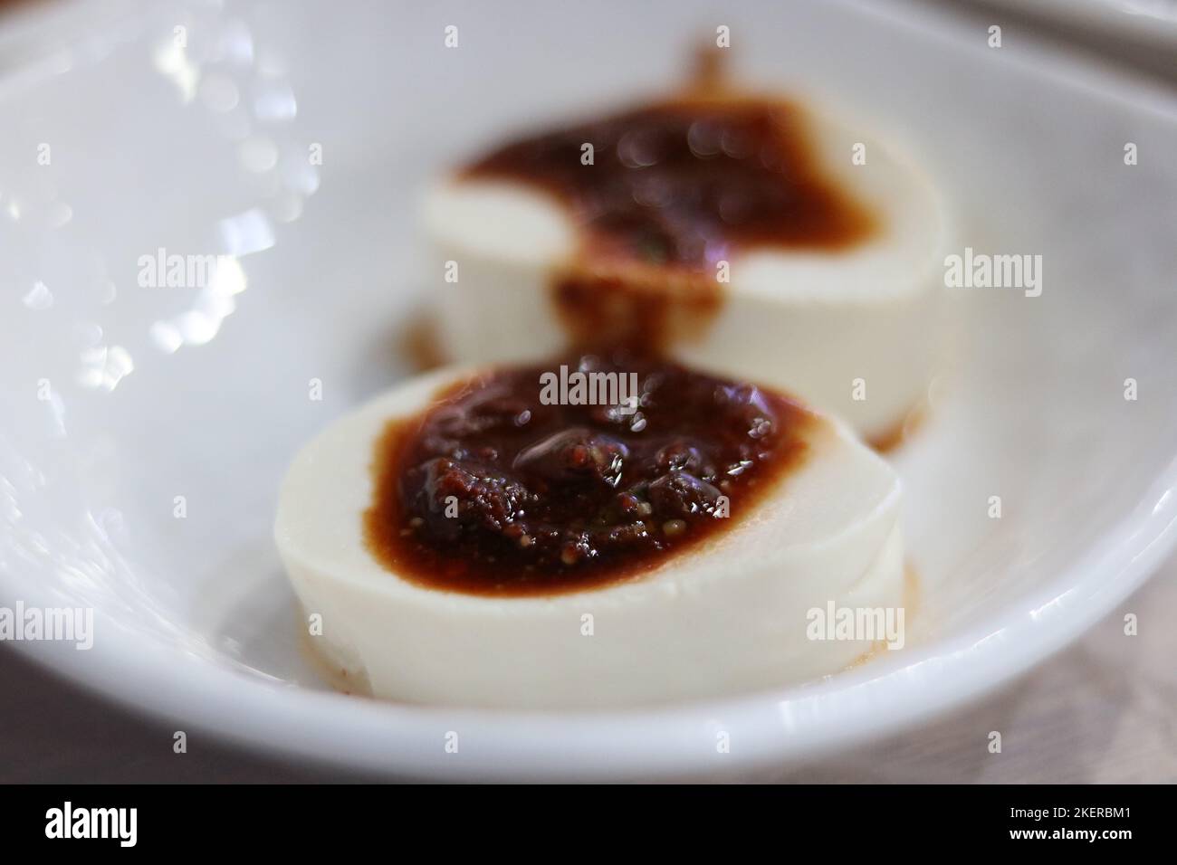 Classic Korean tofu with soy sauce and chilli on plain white dish Stock